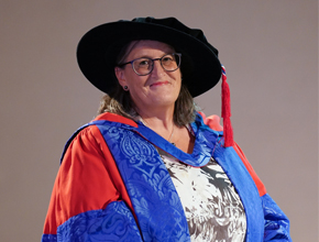 Chancellor Monica Grady smiling wearing cap and gown